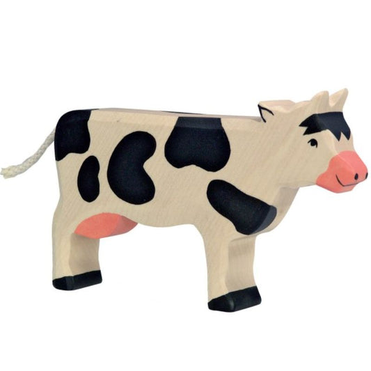 Wooden cow toy with black spots on a white background