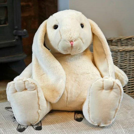 Plush bunny toy on a textured surface with a wicker basket in the background