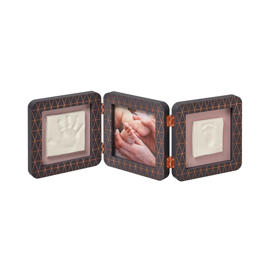 A three-panel baby keepsake photo frame with a dark brown textured patterned border, showing two white footprints and one printed baby photo on a plain white background.