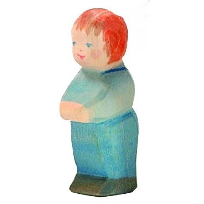 Wooden toy figure of a child with red hair and a blue outfit on a white background