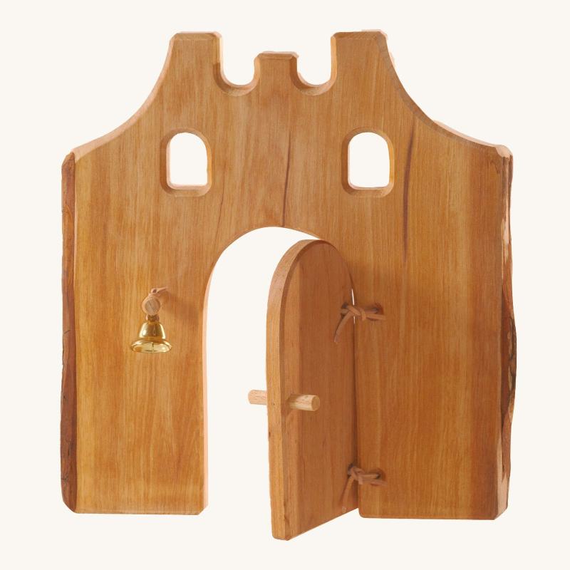 Wooden toy castle gate with a small bell on a white background